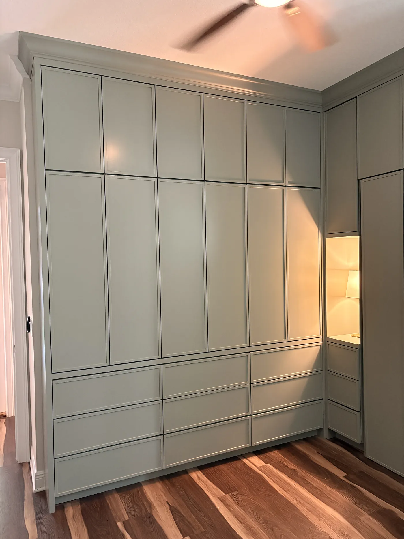 The wall of fitted wardrobes in the Murphy bed room, three banks of drawers along the base and a lit niche at the end