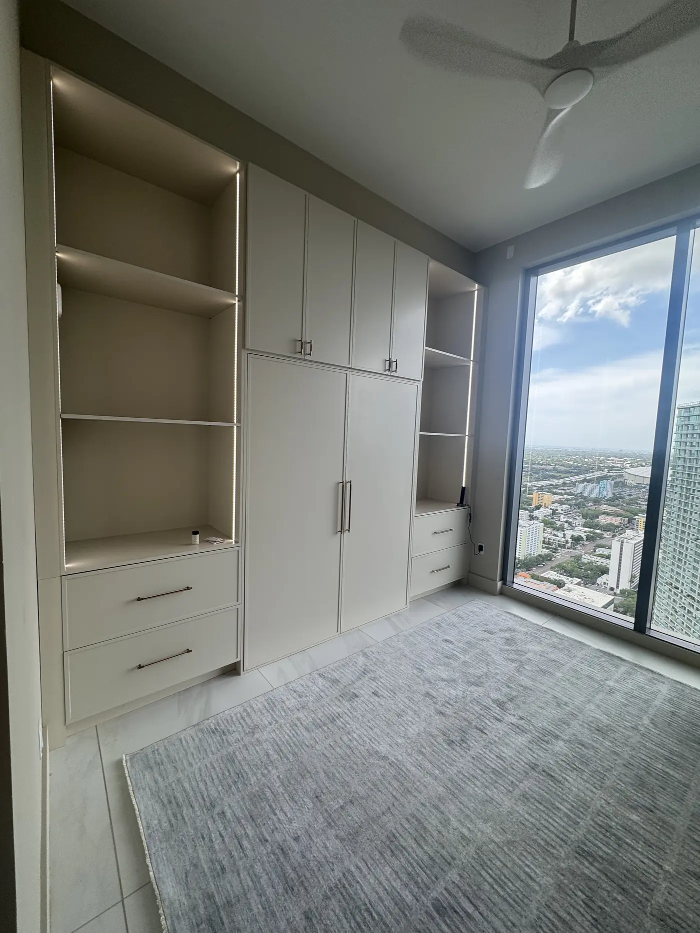 The same Murphy bed closed flush into a run of built in wardrobes and shelving